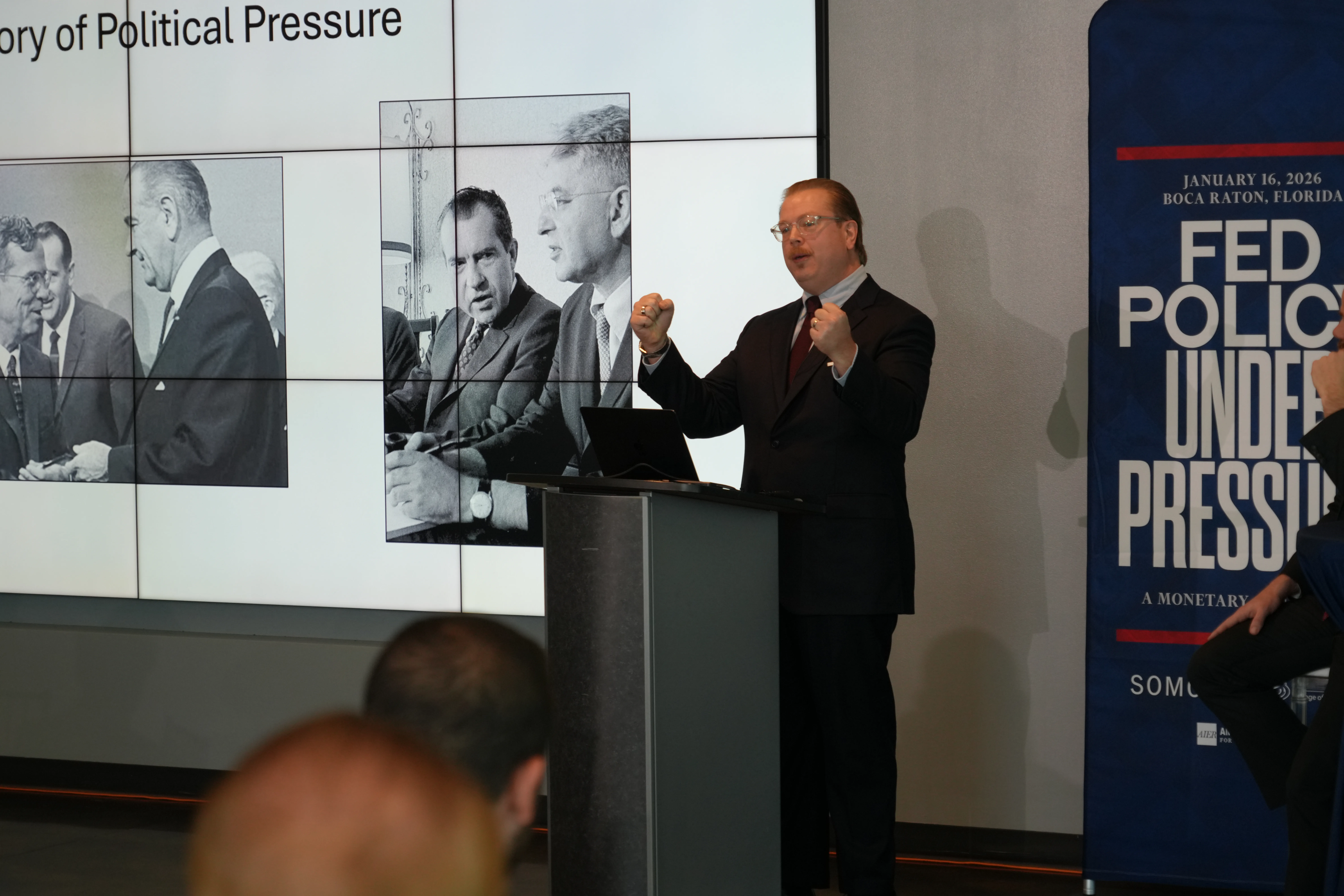 Bryan Cutsinger gesturing while discussing Nixon-era pressure on the Federal Reserve at the AIER Fed Policy Under Pressure conference at FAU